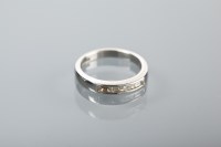 Lot 1133 - DIAMOND SET WEDDING BAND with four countersunk...
