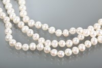 Lot 1154 - THREE STRANDED PEARL NECKLACE formed by white...