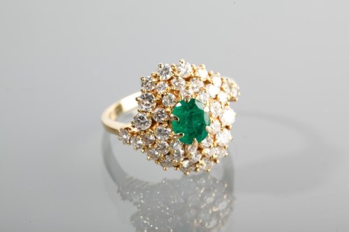 Lot 1250 - EMERALD AND DIAMOND CLUSTER RING the central...