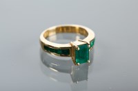 Lot 1319 - EMERALD DRESS RING set with a central emerald...