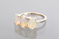 Lot 1156 - OPAL THREE STONE RING the three oval opals set...