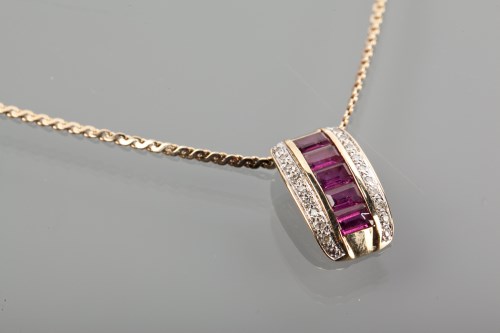 Lot 1174 - RUBY AND DIAMOND PENDANT set with a row of...