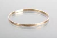 Lot 1201 - NINE CARAT GOLD BANGLE with an engraved...