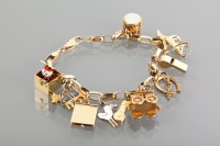 Lot 1227 - NINE CARAT GOLD CHARM BRACELET with charms...