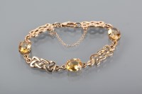 Lot 1256 - NINE CARAT GOLD CITRINE BRACELET with three...