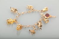 Lot 1181 - NINE CARAT GOLD CHARM BRACELET with various...