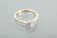 Lot 1245A - DIAMOND THREE STONE RING the emerald cut stone...