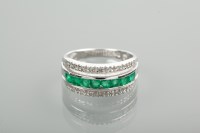 Lot 1318 - EMERALD AND DIAMOND RING with a row of...