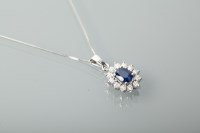 Lot 1394 - SAPPHIRE AND DIAMOND CLUSTER PENDANT the oval...