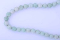 Lot 1881 - SINGLE STRAND OF JADE BEADS the pale green...