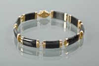 Lot 1223 - BLACK HARDSTONE AND GOLD BRACELET formed by...