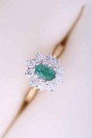 Lot 2079 - EMERALD AND DIAMOND CLUSTER RING the oval...