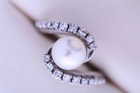 Lot 2105 - PEARL AND DIAMOND DRESS RING the central pearl...