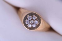 Lot 2176 - DIAMOND SET SIGNET RING set with a flower head...