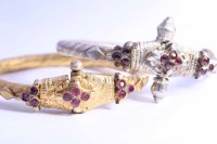 Lot 2204 - TWO INDIAN GILT BANGLES both of similar design,...